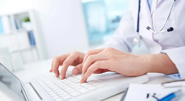 Medical professional typing at a computer