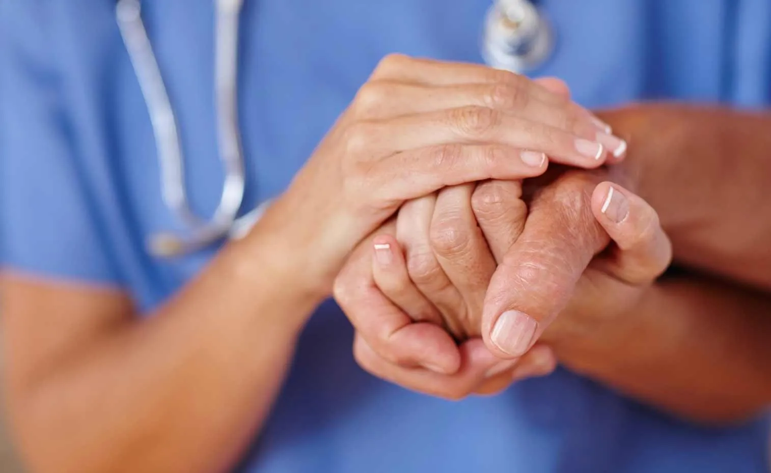 Medical professional holding a patient's hands